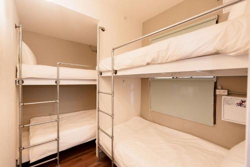 two bunk beds in a room with wooden floors at May Rooms Taipei NTU in Taipei