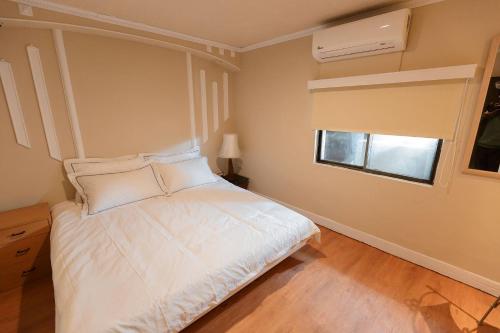 a bedroom with a white bed and a window at May Rooms Taipei NTU in Taipei