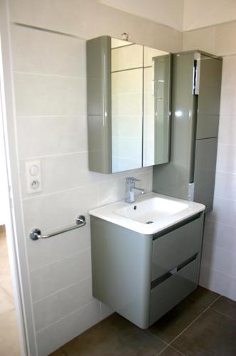 une salle de bain avec un lavabo et un miroir dans l'établissement Résidence Terre et Mer, à Sainte-Lucie de Porto-Vecchio