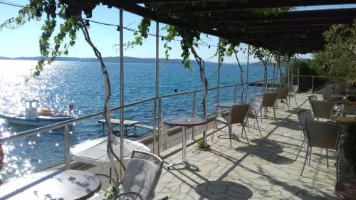 a view of the water from a restaurant with tables and chairs at Pension Augustino in Ražanac