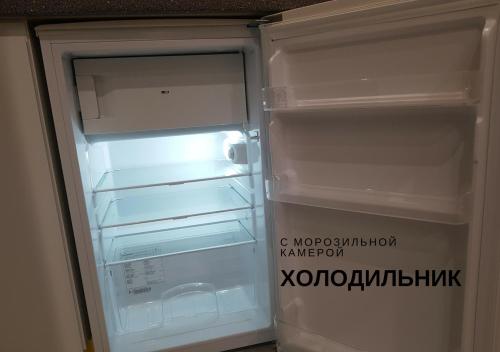an empty refrigerator with its door open in a room at Комфортні мині-апартаменти студіо на Юлії Здановської in Kyiv