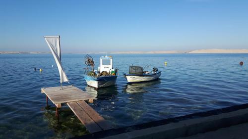 two boats in the water next to a dock at Pension Augustino in Ražanac