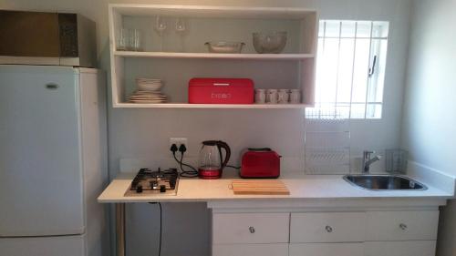 a kitchen with a counter with a sink and a stove at Feet Up Cottage in Somerset West