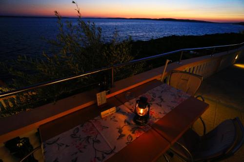a table on a balcony with a view of the ocean at Pension Augustino in Ražanac