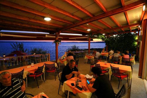 a group of people sitting at tables in a restaurant at Pension Augustino in Ražanac