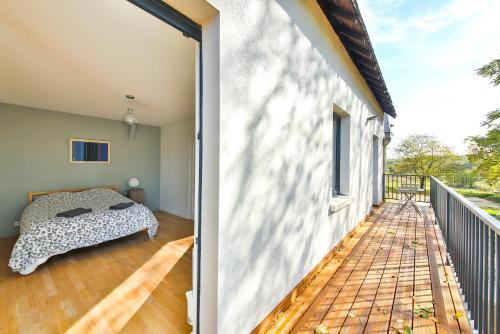 um quarto com uma cama numa varanda em Les Terrasses De Chaumont 1 em Montsoreau