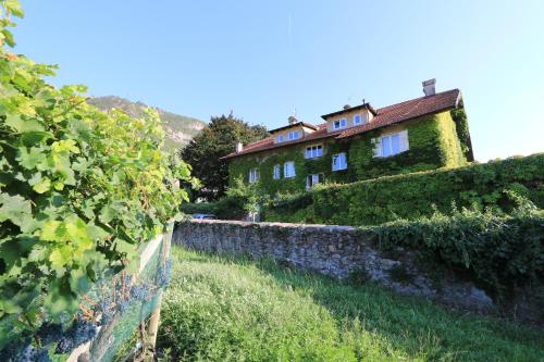 an old house with a stone wall and vines at Appartamento "Rio Nero" in Ora/Auer