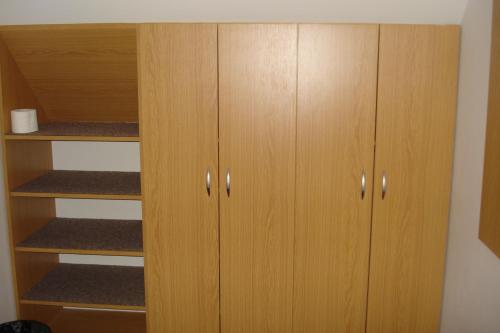 a closet with wooden cabinets in a room at Penzion Seidl in Rokytnice nad Jizerou
