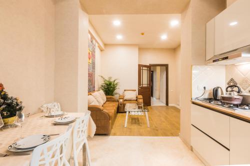 a kitchen and living room with a couch and a table at Sweet Home Apartment VIP 1 in Tbilisi City