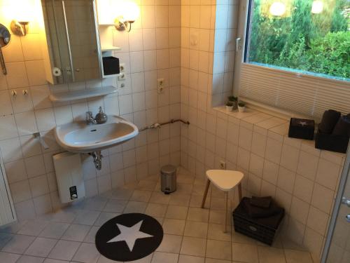 a bathroom with a sink and a mirror and a sink at Strandstern mit Wallbox in Wremen