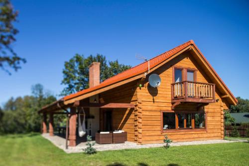 Cabaña de madera con porche y balcón en Kamionka House - Dom z Bala, en Biskupiec