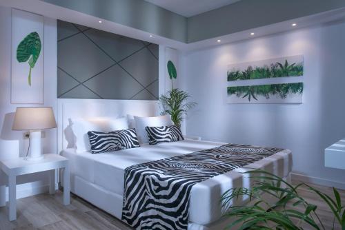 a white bedroom with a zebra print bed and a table at Fodele Beach Water Park Resort in Fodele