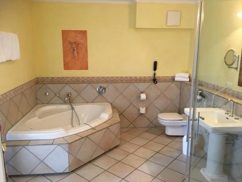 een badkamer met een bad, een toilet en een wastafel bij Hotel Landhaus Milser in Duisburg