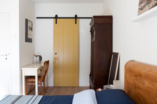 1 dormitorio con 1 cama y puerta de madera en B&B PeperZzz, en Bergen