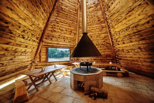 a log cabin with a table and a stove in it at Zajazd Chyżne in Chyżne