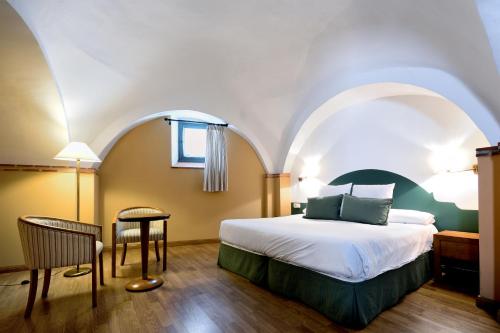 Säng eller sängar i ett rum på Hotel Ahc Palacio Coria