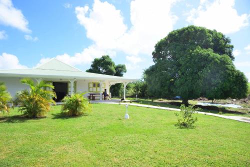 a house with a green lawn in front of it at Residence Clementine villa Douceur in Grand-Bourg