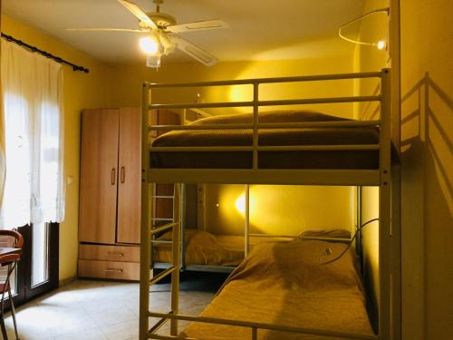 two bunk beds in a room with a ceiling fan at Studios Arabas in Thessaloniki