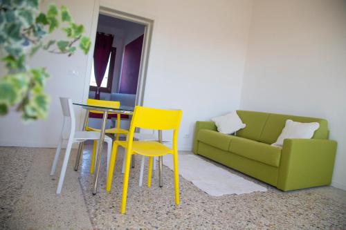 a living room with a couch and a table and chairs at Murano Canal View in Murano