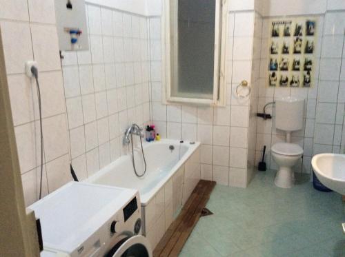 a bathroom with a tub and a toilet and a sink at Comebackpackers in Budapest