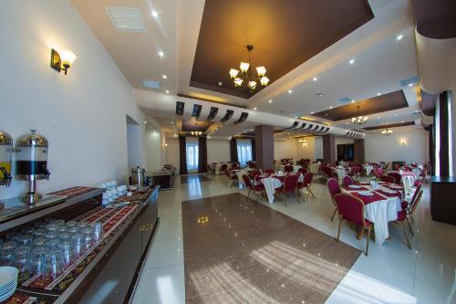 a restaurant with tables and chairs in a room at Alpina Resort by Stellar Hotels, Tsaghkadzor in Tsaghkadzor
