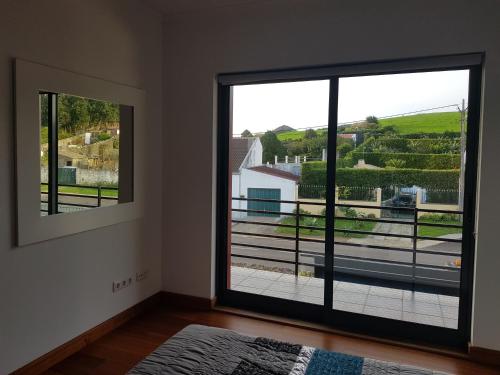 Habitación con una gran puerta de cristal con vistas. en Deluxe Home Praia do Populo, en Cabouco