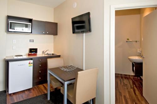 a small kitchen with a table and a sink at 540 on Great South Motel in Auckland
