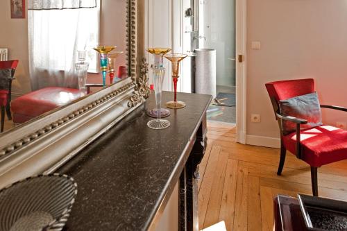 a living room with a mirror and a red chair at Maison d'Hôte de Myon in Nancy