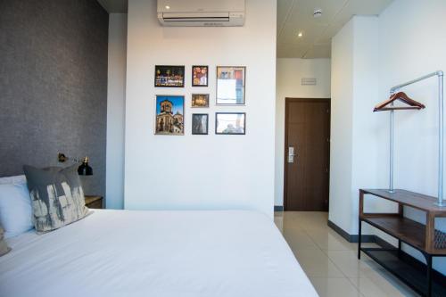 a bedroom with a white bed and a table at The Lights City Rooms in Málaga