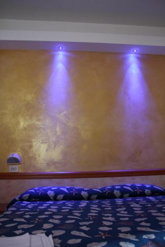 a room with a wall with two lights on it at Hotel Montmartre in Rimini