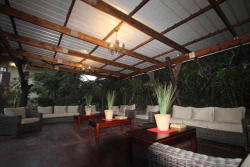 a patio with couches and tables and a pergola at Forest Lodge in St Lucia