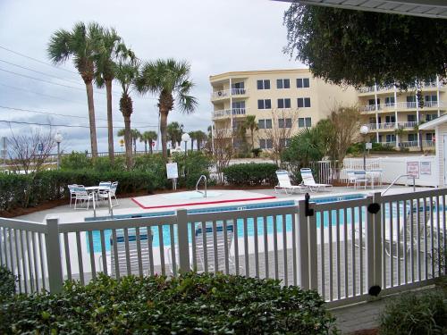 a pool with chairs and a table and a building at Summerspell Condominum in Destin