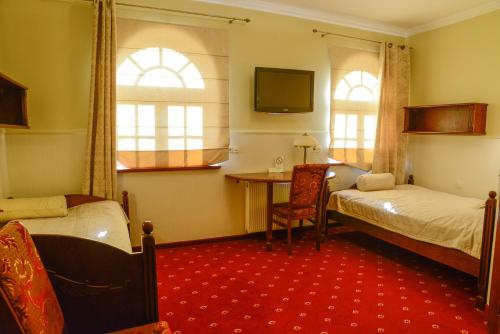 Cette chambre comprend 2 lits, une table et une fenêtre. dans l'établissement Revita, à Józefów