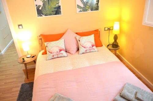 カディスにあるApartamento La Sorpresa de Cádizのベッドルーム1室(ピンクの枕2つ、ベッド1台付)
