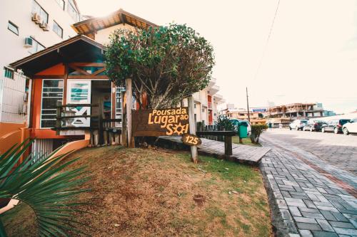 a building with a sign on the side of a street at Pousada Lugar ao Sol in Bombinhas