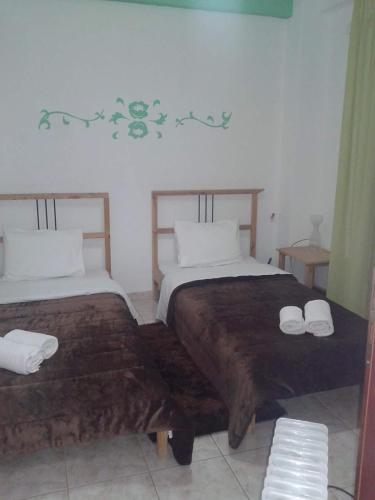 a bedroom with two beds with towels on them at Villagiannis in Nea Fokea