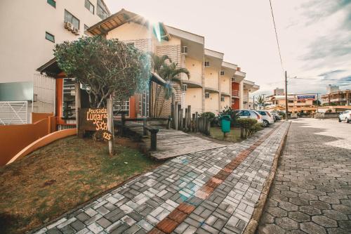 a sidewalk with a tree next to a building at Pousada Lugar ao Sol in Bombinhas