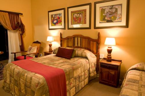 a bedroom with a bed and two lamps and two chairs at Primavera Guest House in Bloemfontein