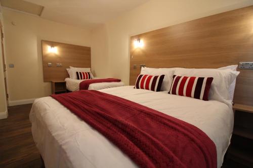 a bedroom with a large bed with red and white pillows at Townlets Serviced Accommodation Salisbury in Belfast