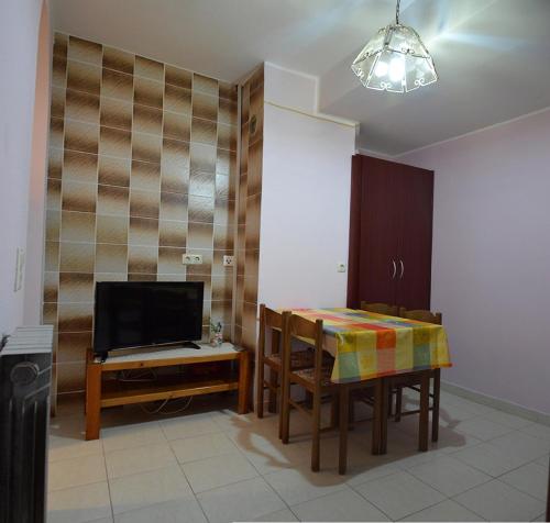a dining room with a table and a television at Apartments "Ruža" in Vodice
