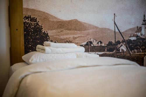 a group of white pillows sitting on top of a bed at Antošíkov majer in Banská Štiavnica