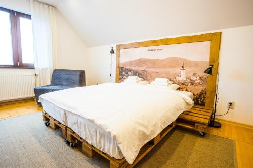 a bedroom with a large bed and a chair at Antošíkov majer in Banská Štiavnica