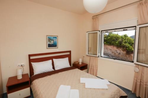 コリオスにあるVilla Anemoessaのベッドルーム1室(ベッド1台、大きな窓付)