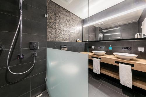 a bathroom with two sinks and a shower at ABC Swiss Quality Hotel in Chur