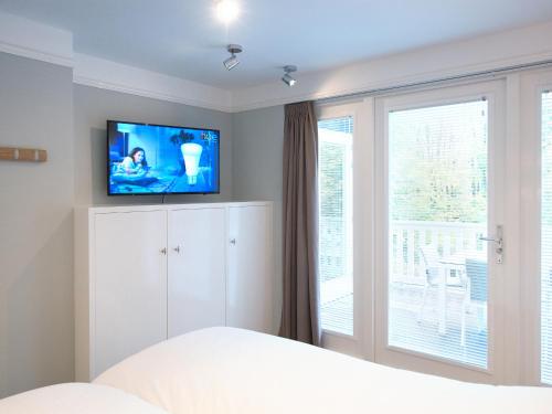 um quarto com uma cama e uma televisão na parede em Bizstay Park Central Executive em Haia