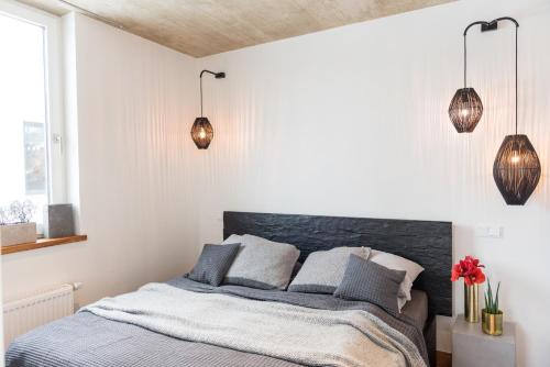 a bedroom with a bed and two pendant lights at N8Quartier Eifel in Bad Münstereifel