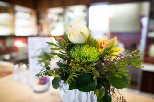 a vase with a bouquet of flowers on a table at Olympia Hotel Zurich in Zürich