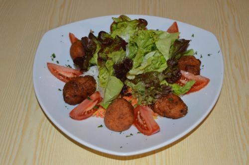 a plate of food with a salad on a table at Gasthof Zahler in Röfingen