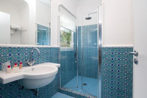 
a bathroom with a shower, sink, and tub at Hotel Bougainville in Positano
