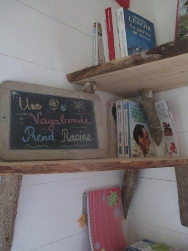 a shelf with a chalkboard and books on it at Roulotte coin de nature in Lannion